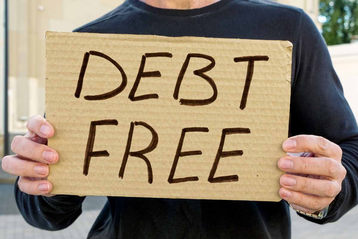 Picture of a man holding a debt-free poster.