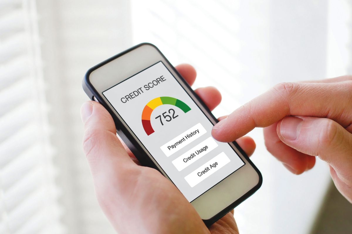 A man's hand checking his credit score.