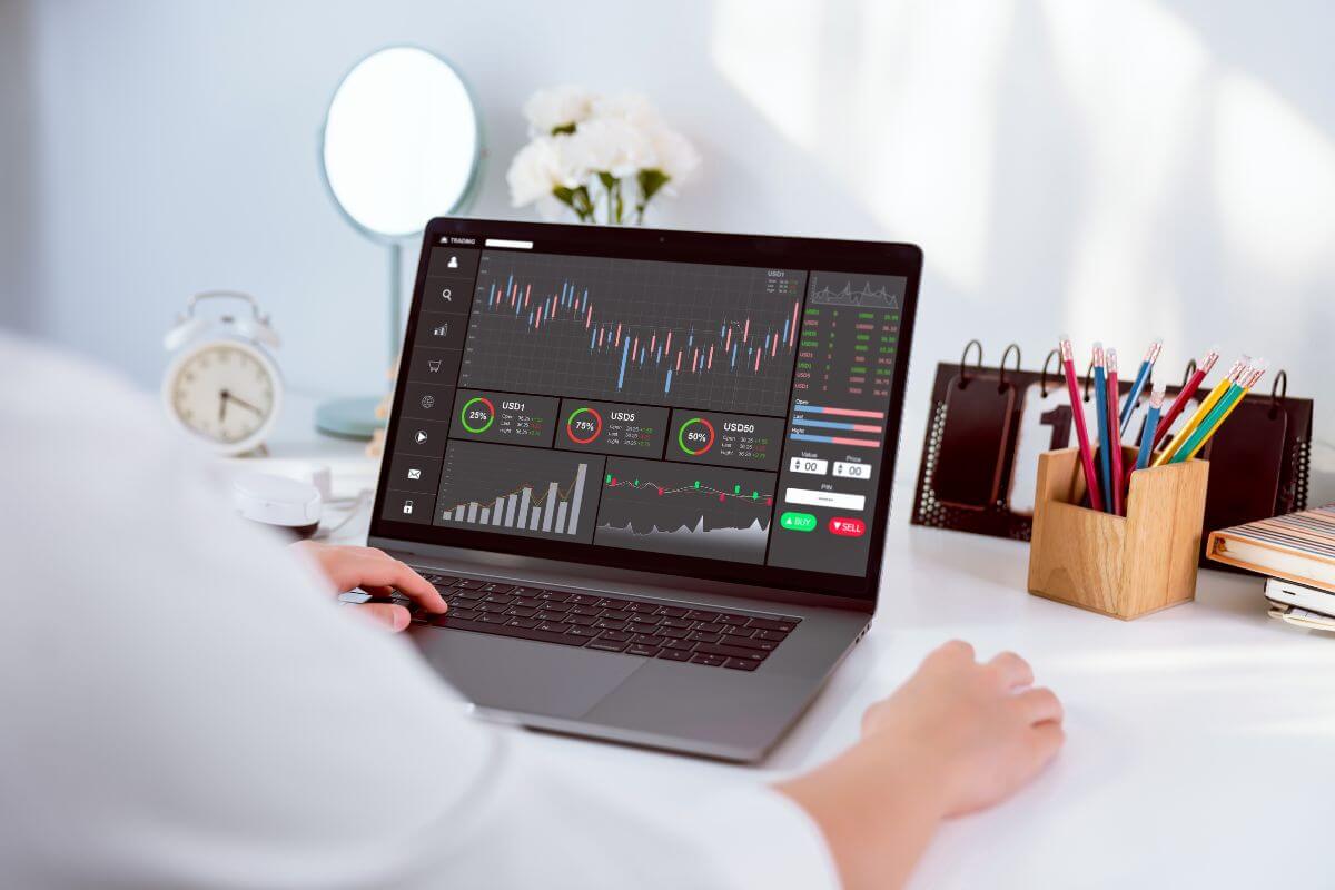 The image of the man using a laptop and monitoring to indicate go big and trade options contracts to potentially make more money.
