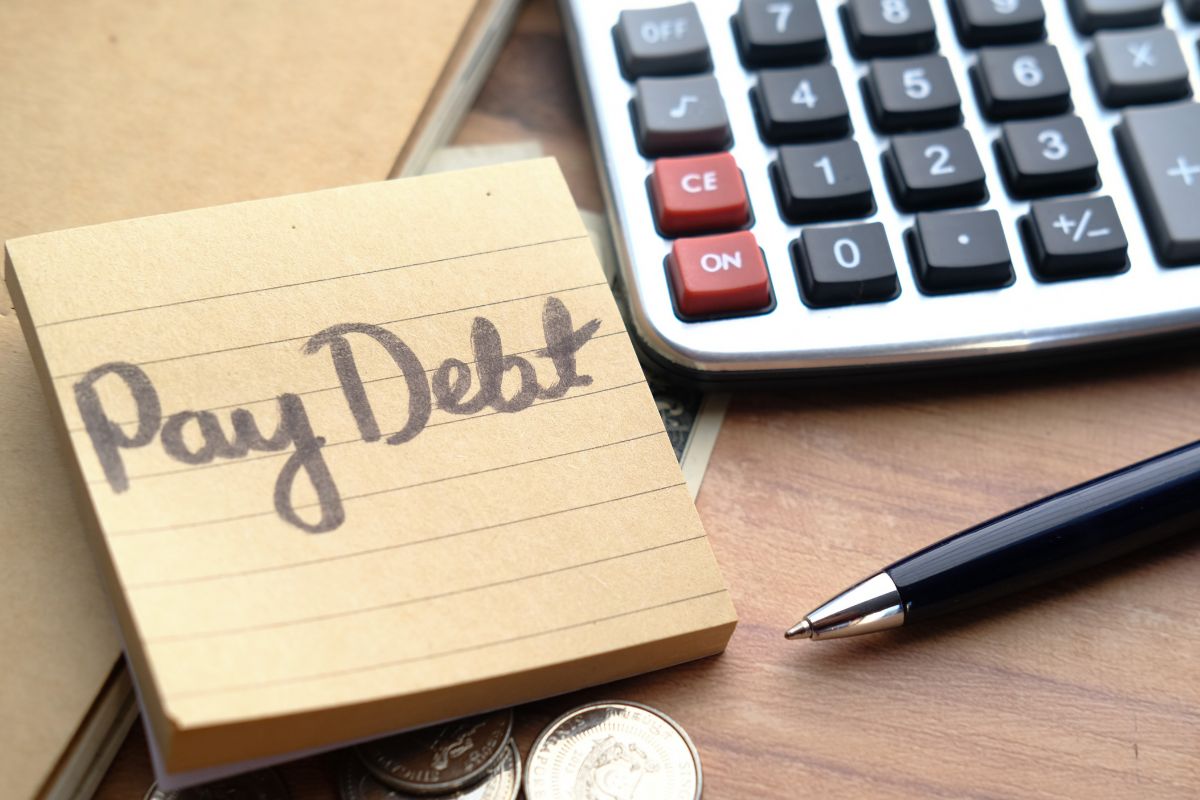 Photo of a paper with pay debt wording.