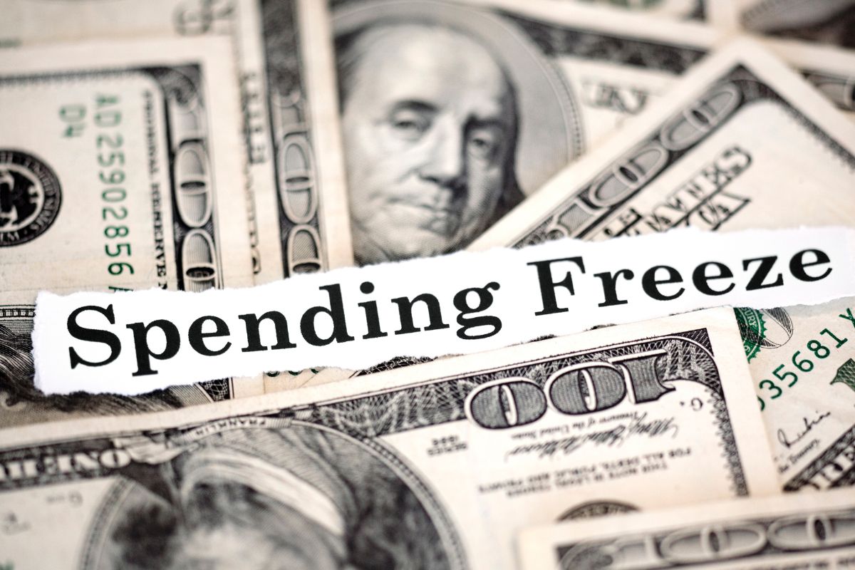 Picture of money and spending freeze wording.