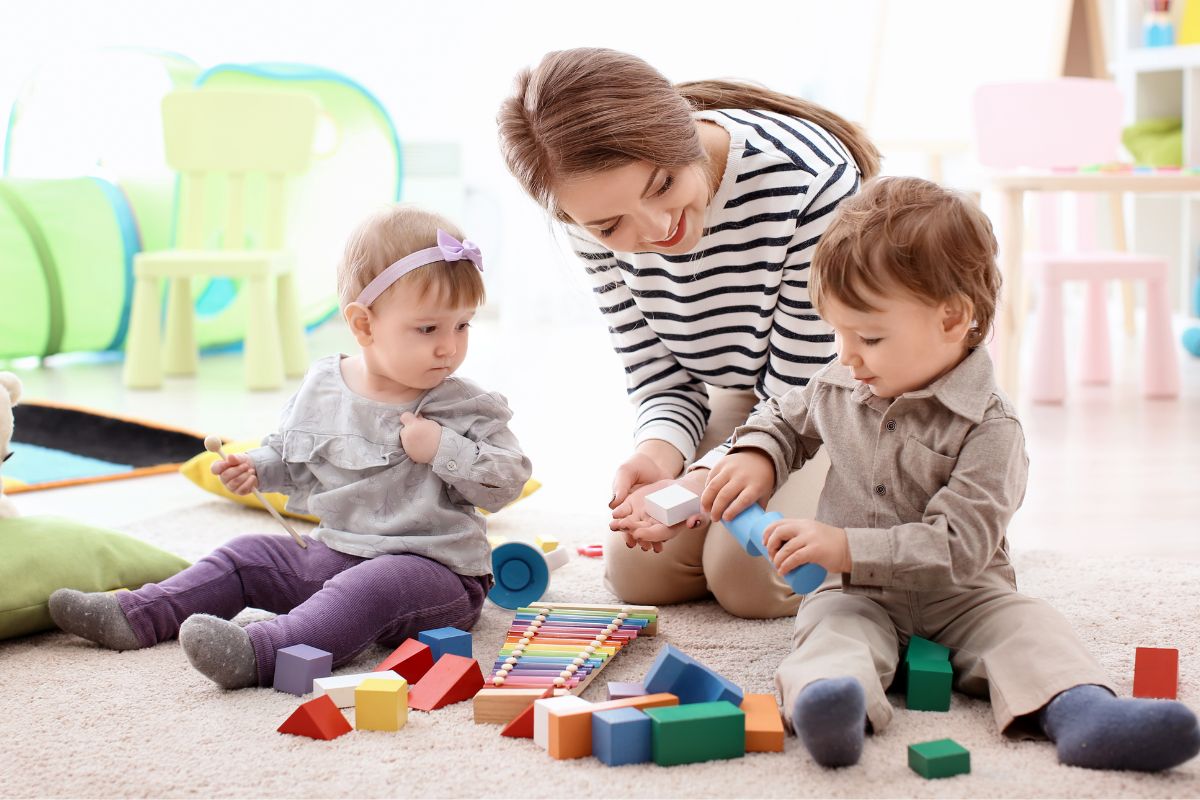The image shows a nanny taking care of little children.