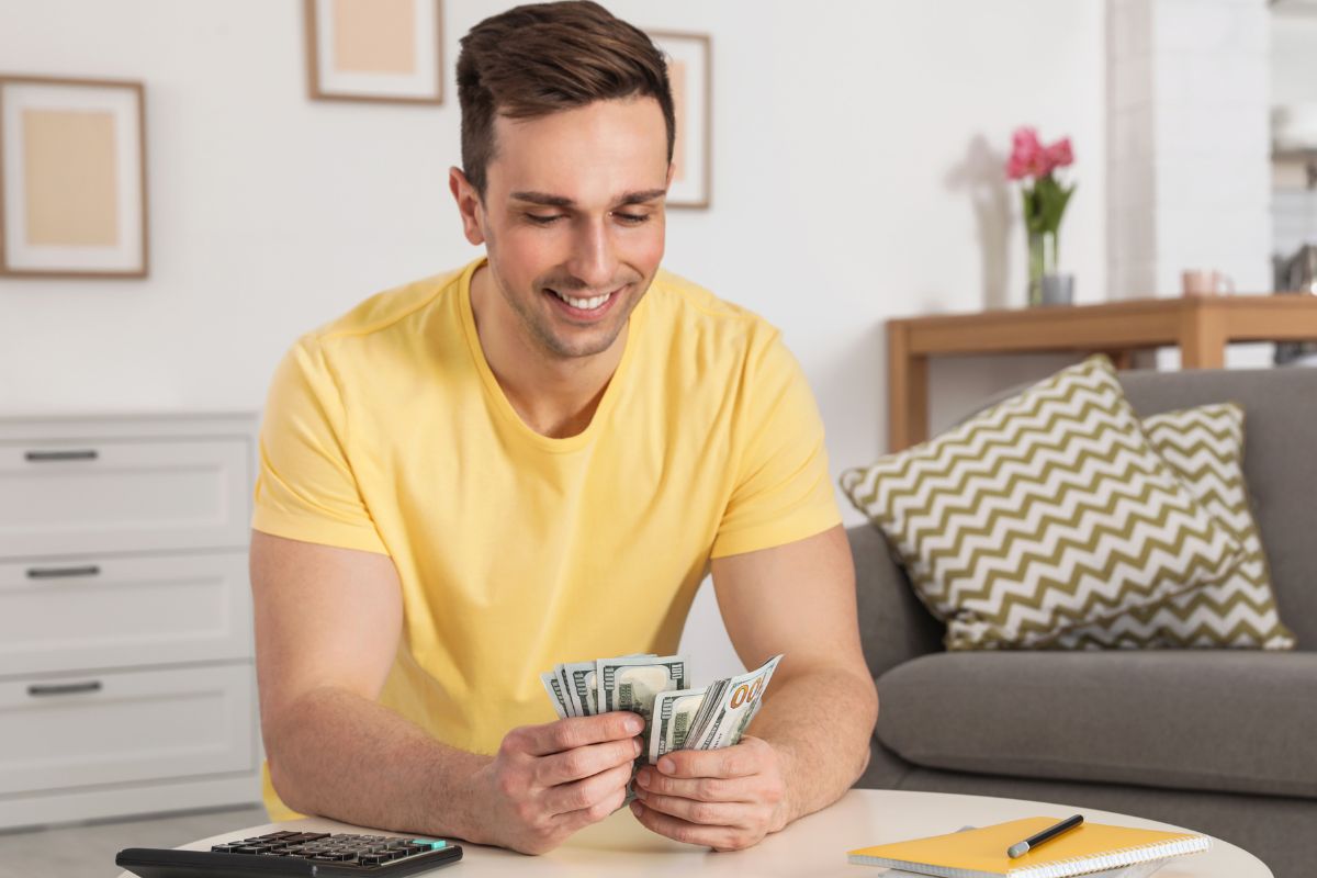 Foto de um homem contando dinheiro.