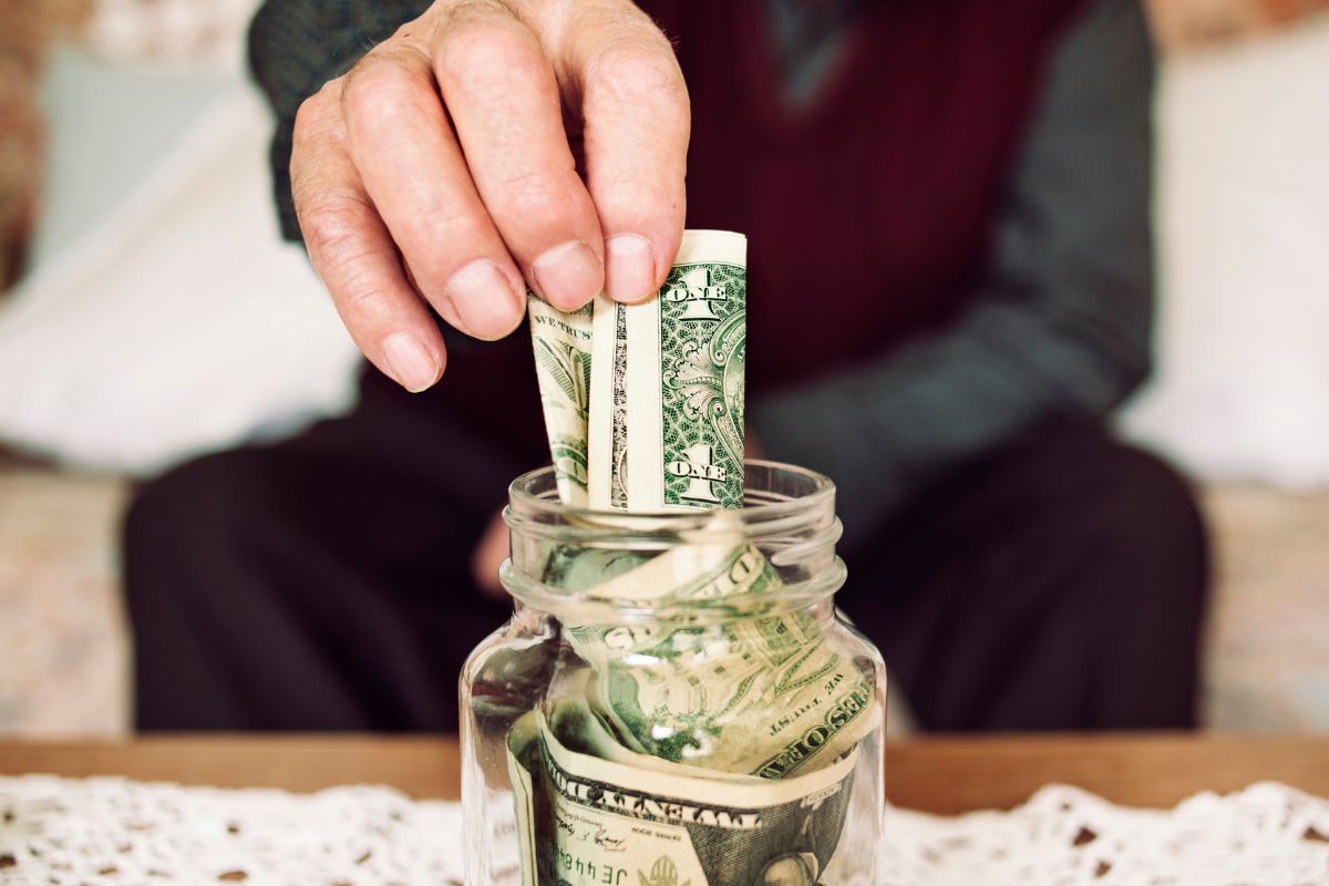 Photo of a senior man's hand saving money.