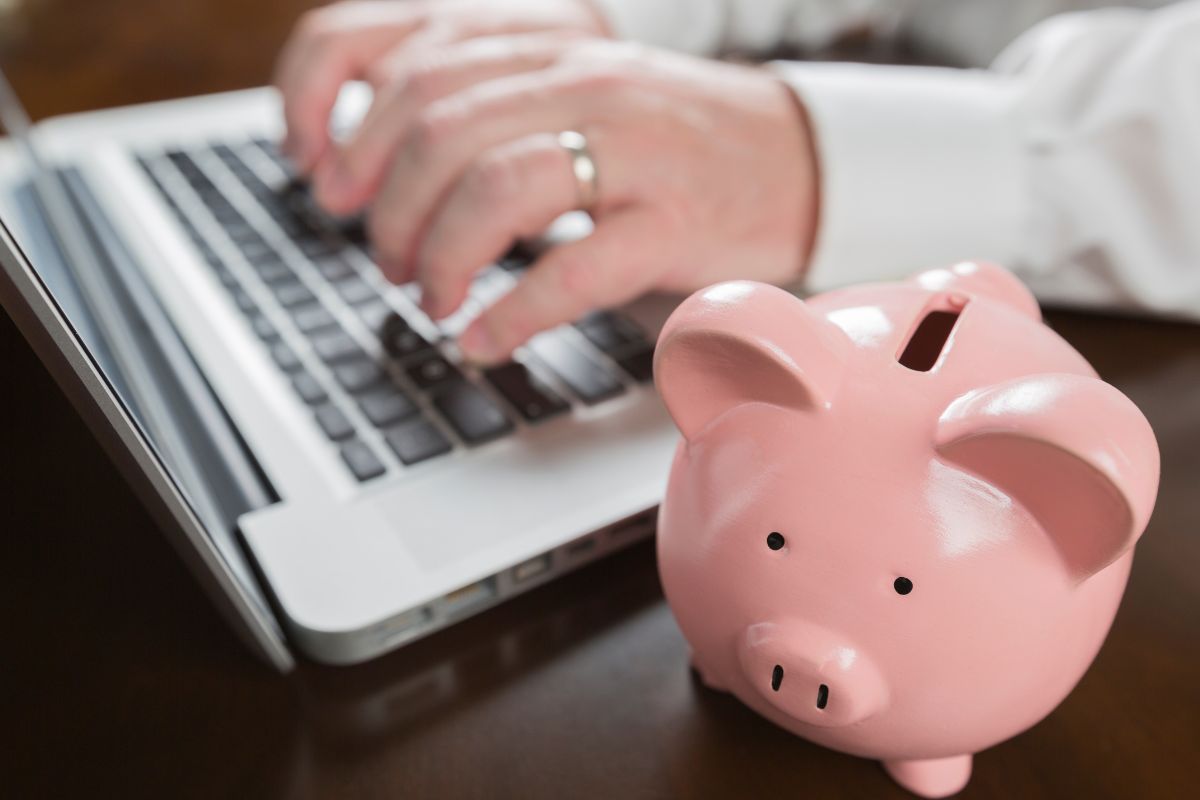 Picture of a man's hand typing on a laptop.