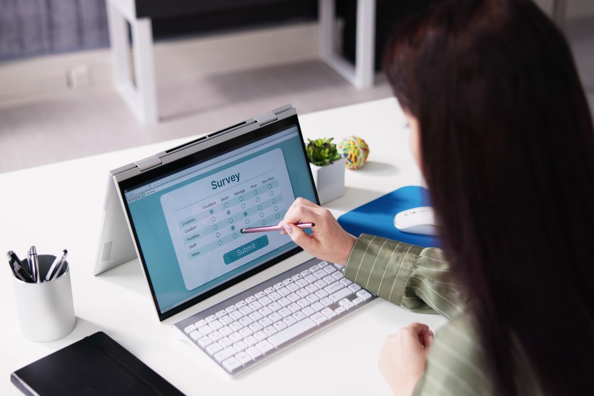 The picture shows a young lady taking an online survey.