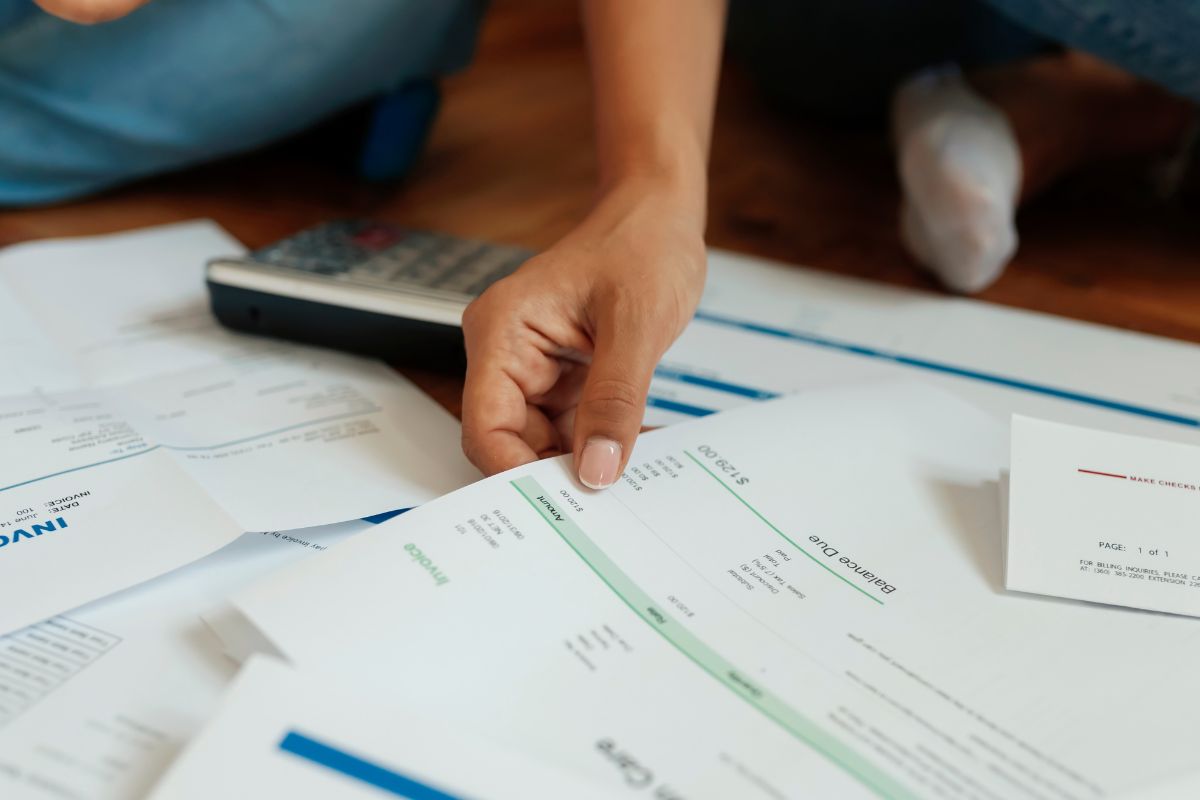 A man's hand reviewing his debts.