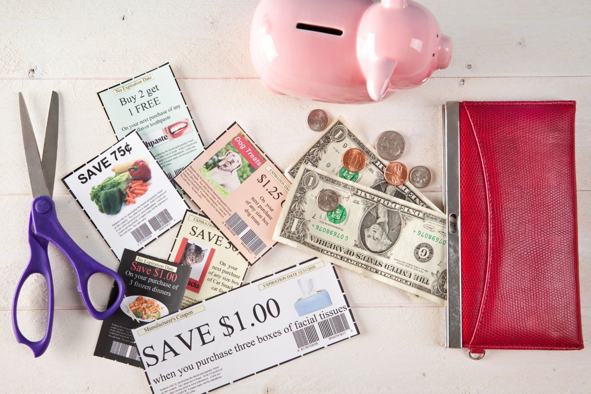 Photo of coupons, a wallet, and a piggy bank.