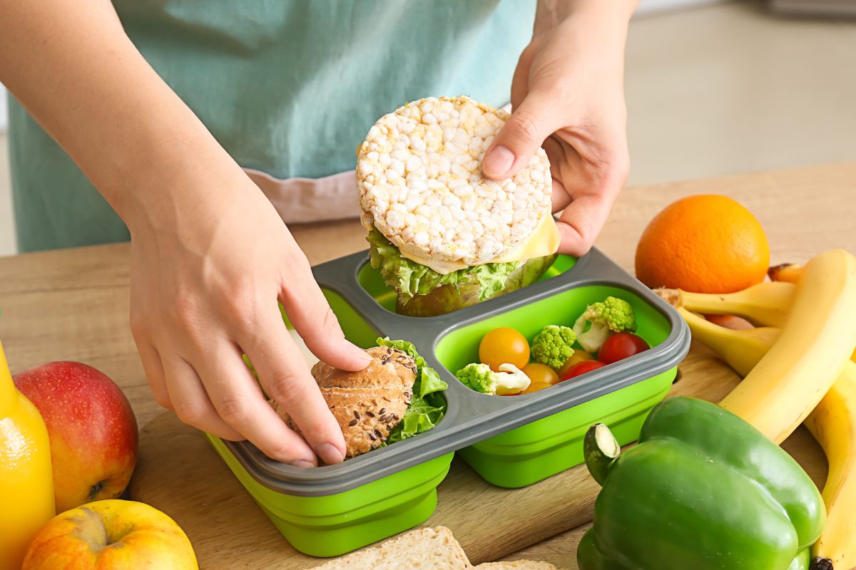 A woman's hand preparing her packed lunch.