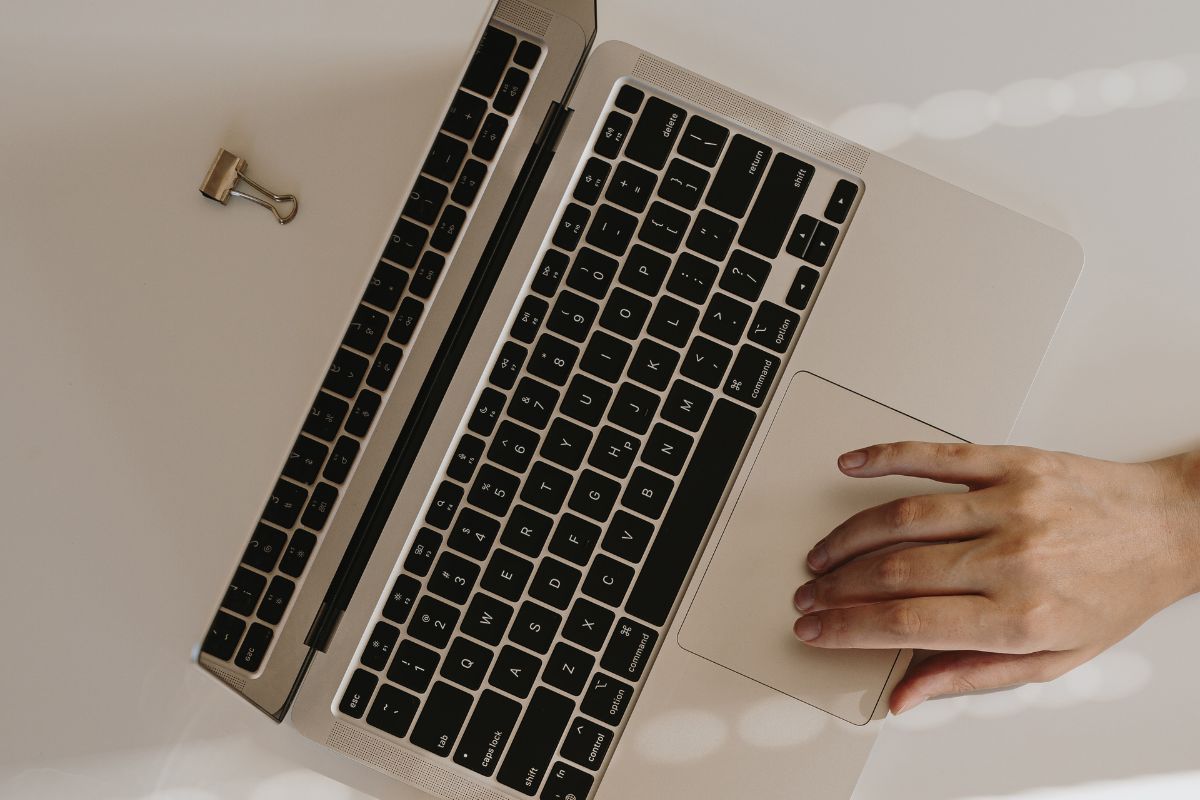 Photo of a woman's hand using a laptop.