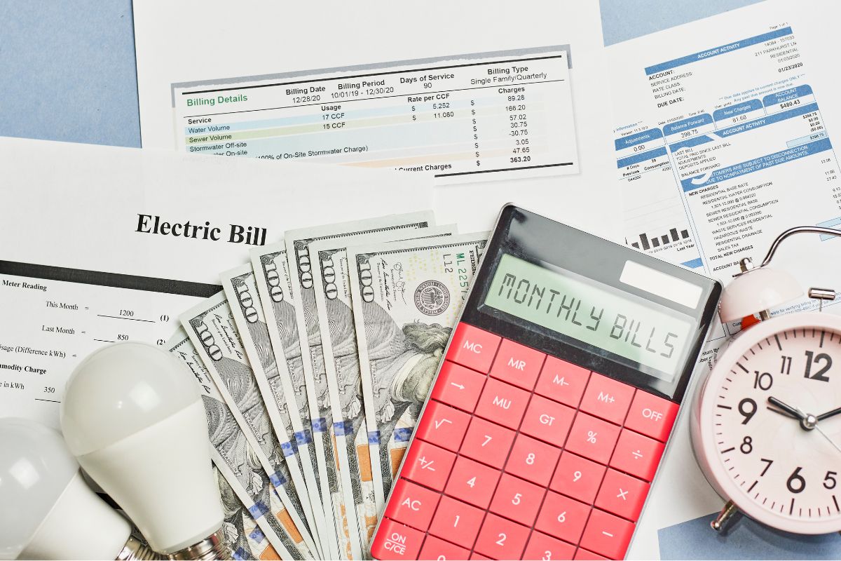 Image shows money and monthly bills.