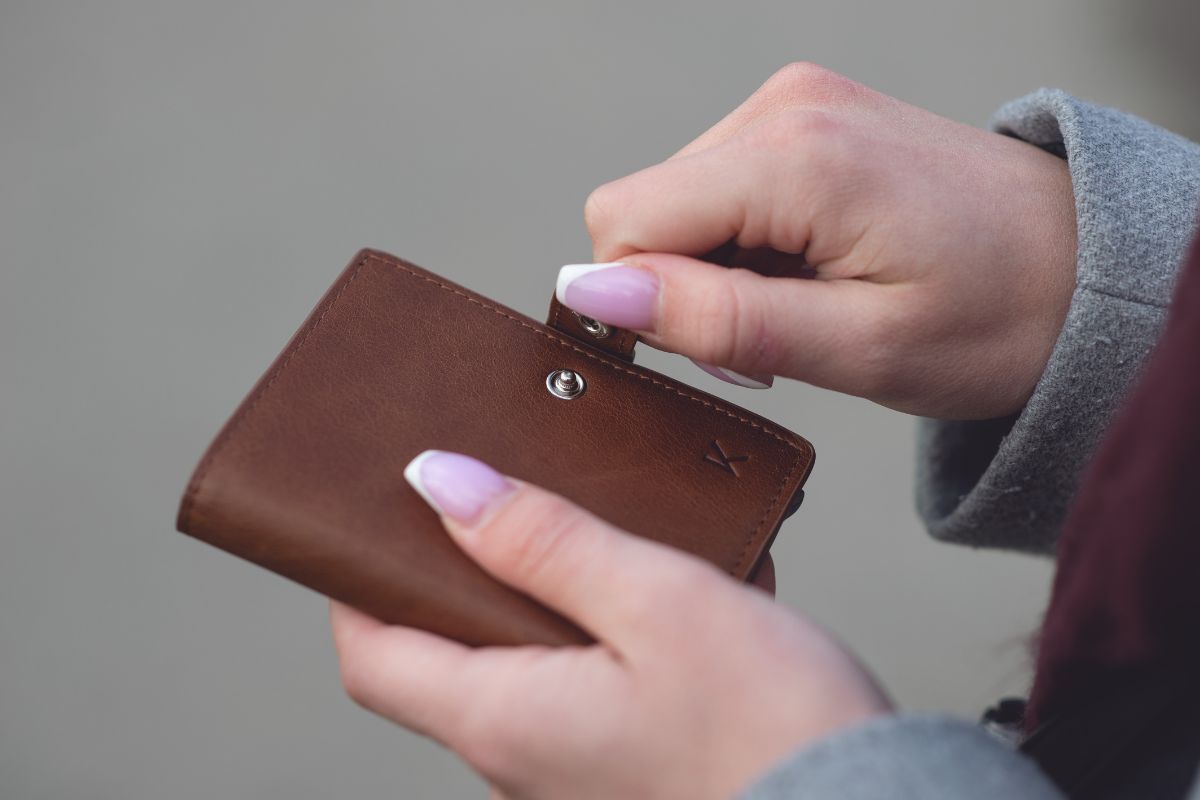 Picture of a woman's hand closing her wallet.