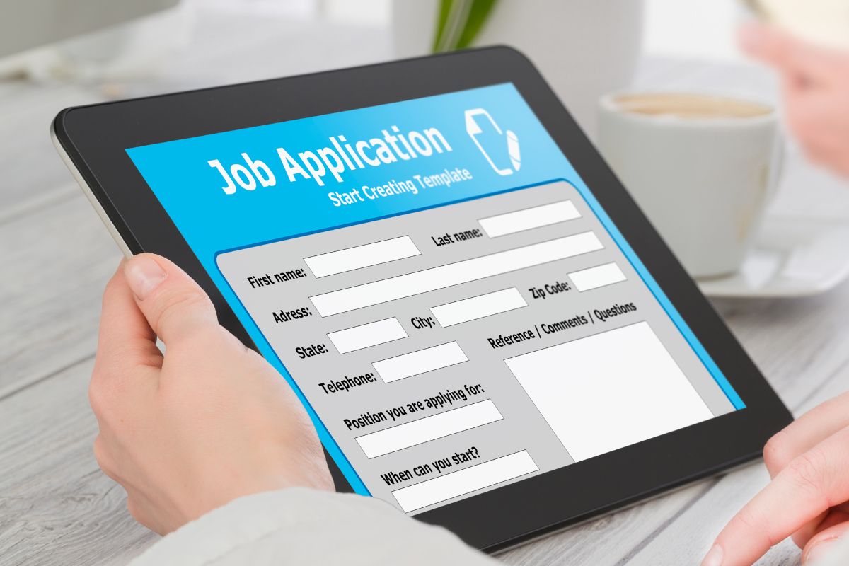Image of a woman's hand filling out the job application.