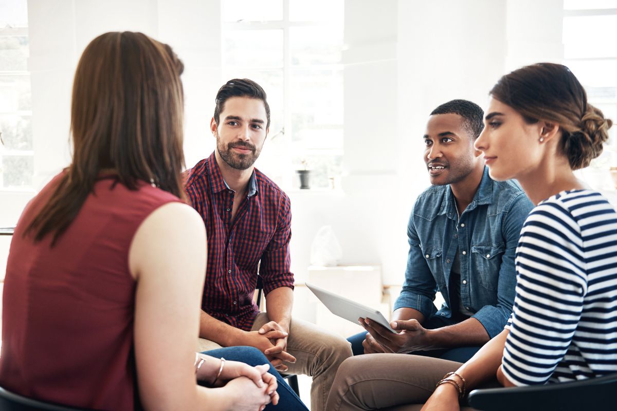 The image shows a group of people having a meeting.