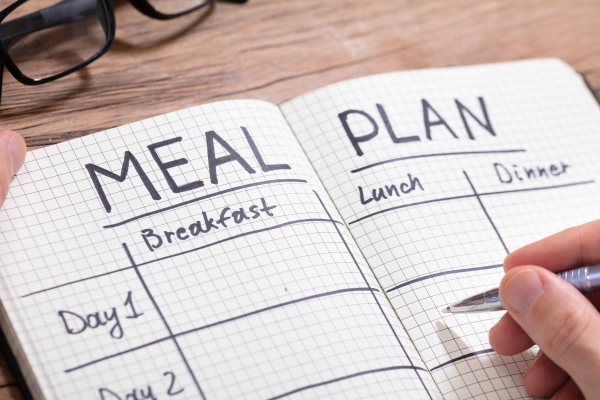 Picture of a man's hand making a meal plan.