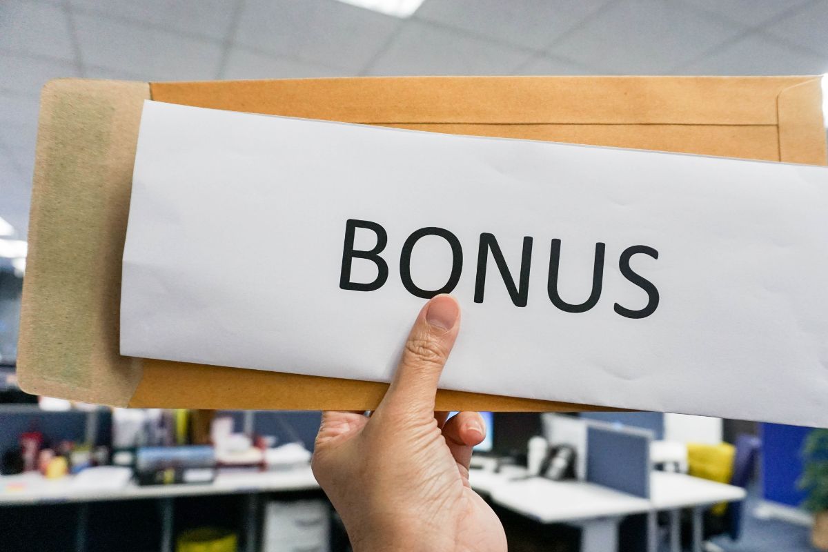 A woman's hand holding a bonus envelope.