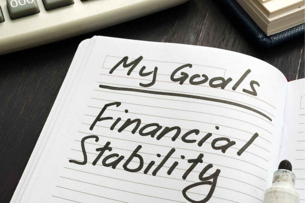 Imagem de um caderno com metas de estabilidade financeira.