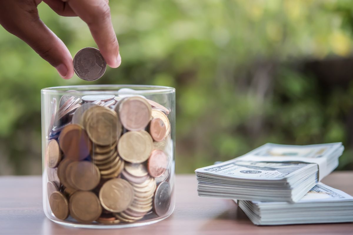 A mão de uma mulher economiza dinheiro.