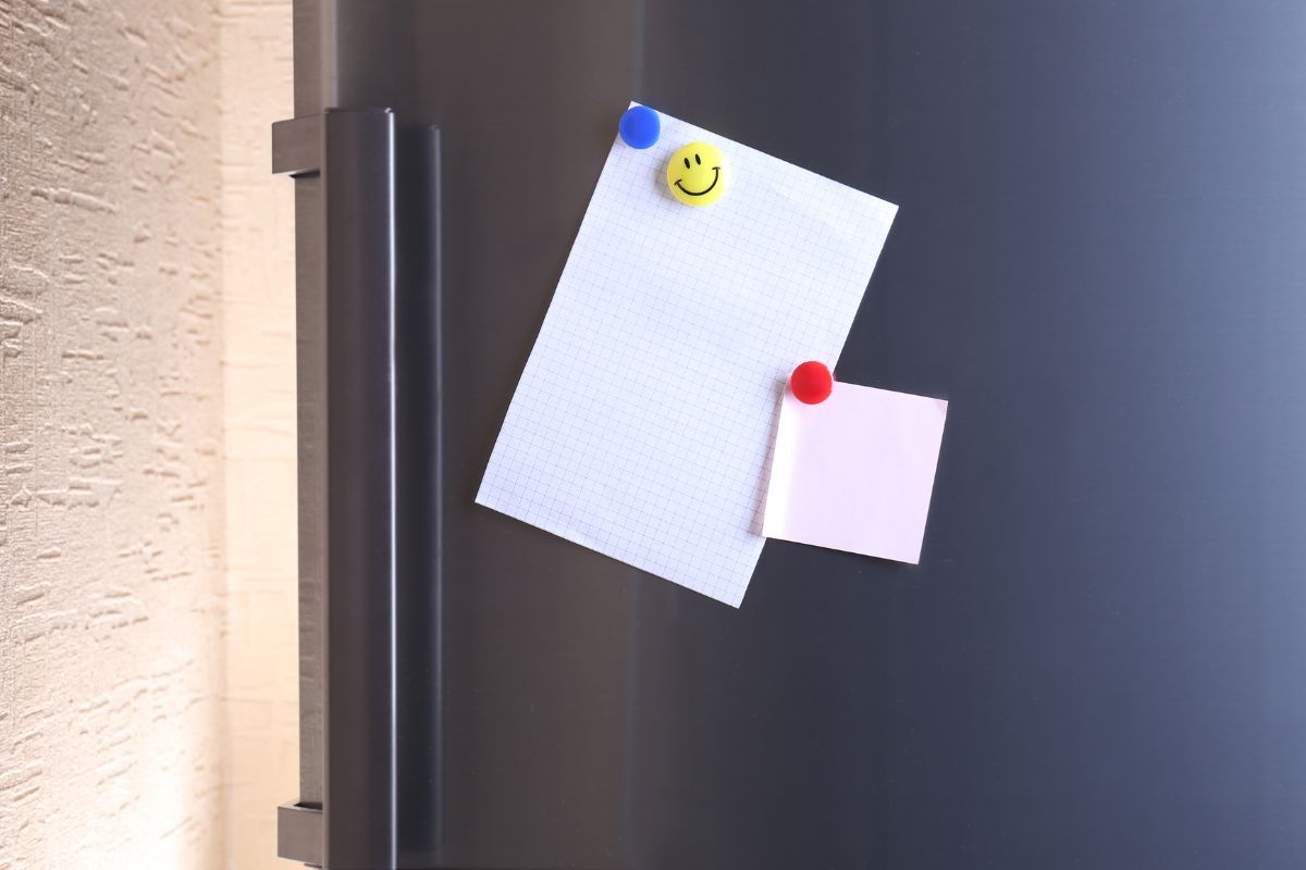 Imagem de papéis grudando na geladeira.