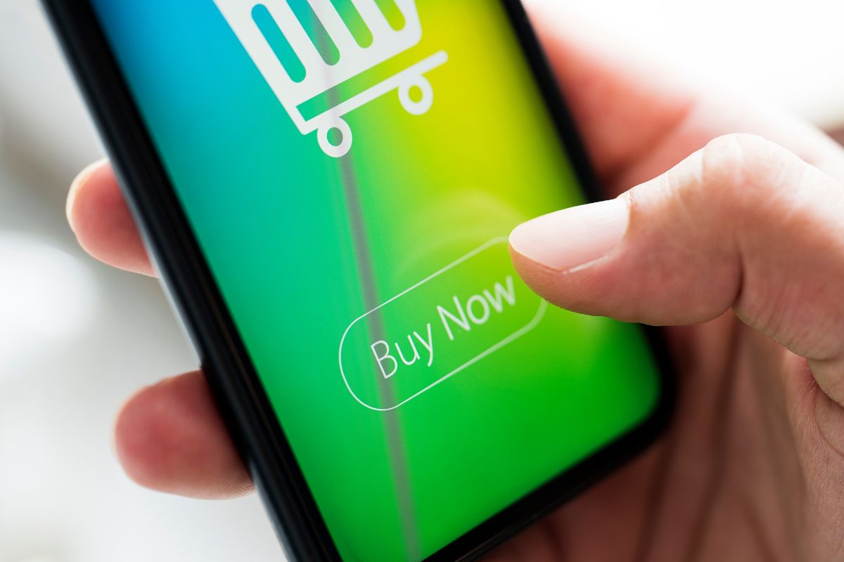 A mão de um homem usando um aplicativo de compras.