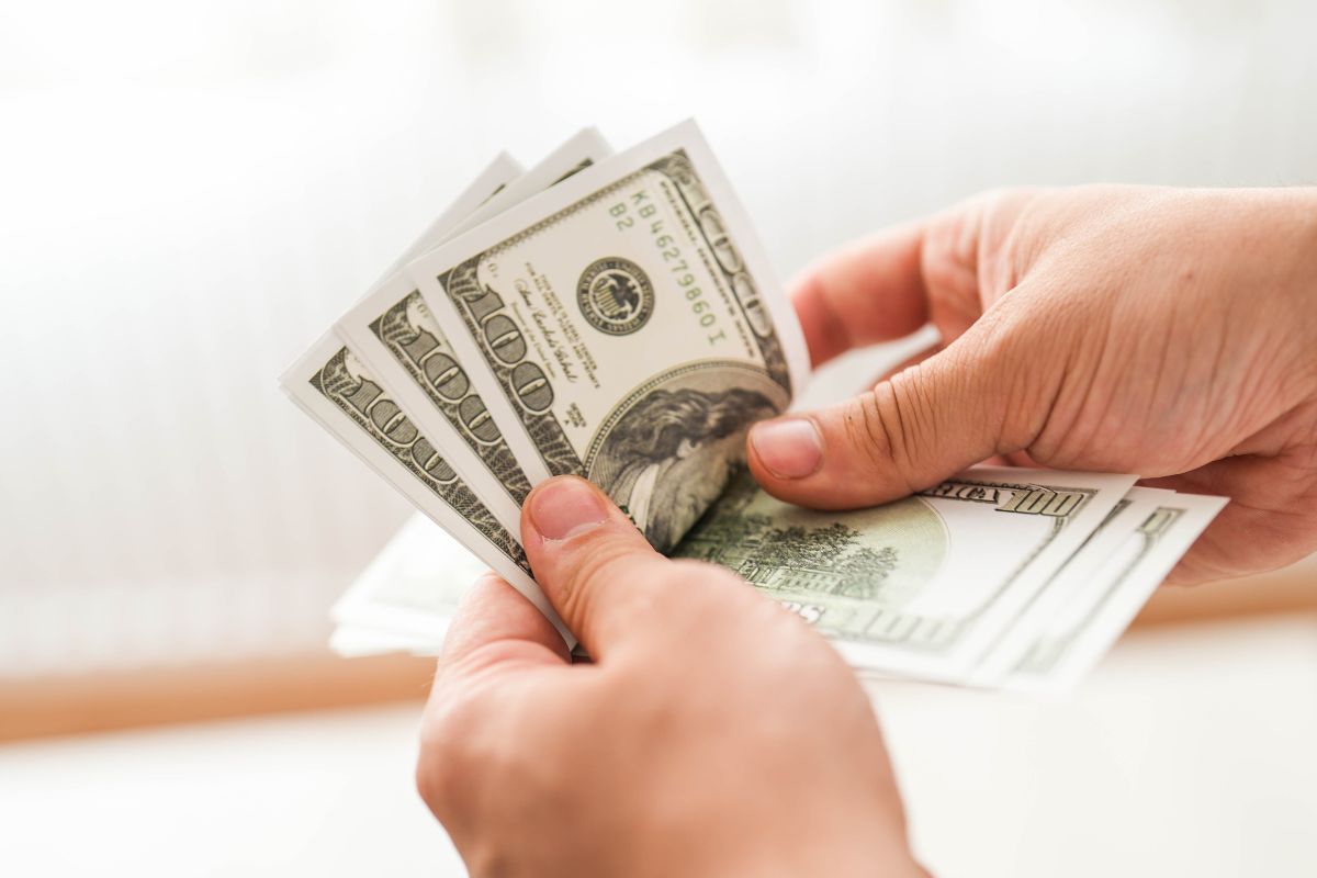 Image of a man's hand counting money.