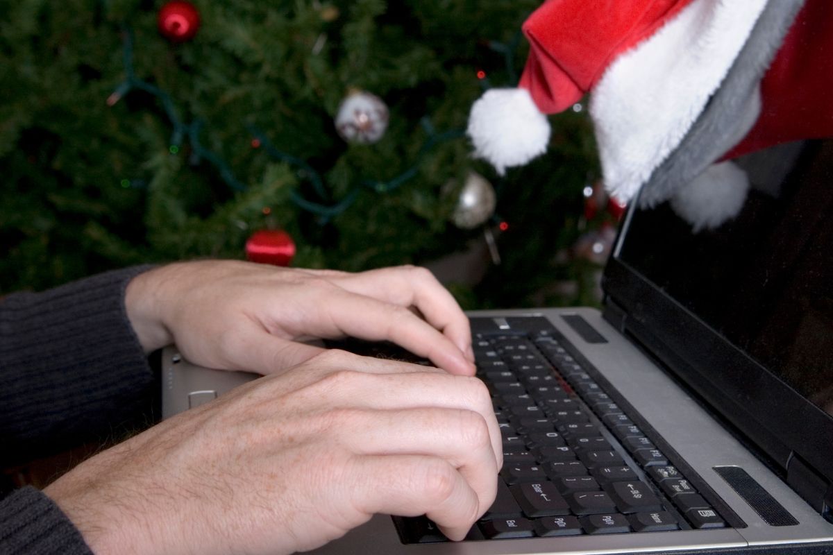 Photo of a man's hand using a laptop.