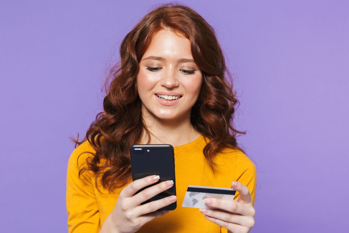 Photo of a young lady using a credit card.