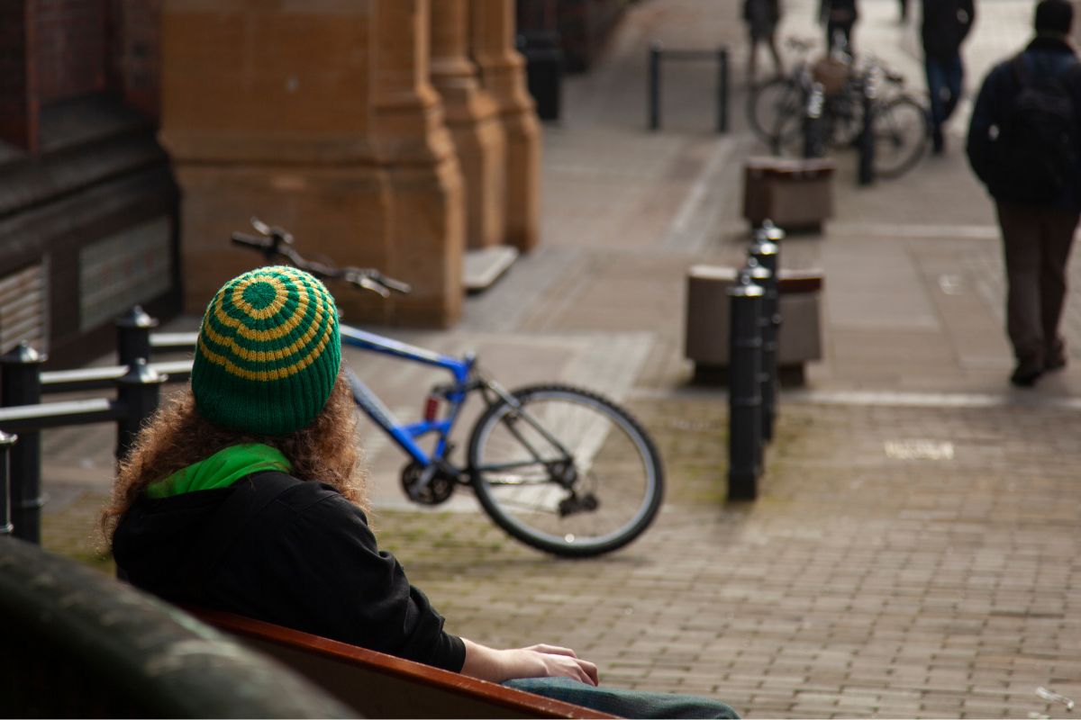 Photo of a woman people watching in the street.