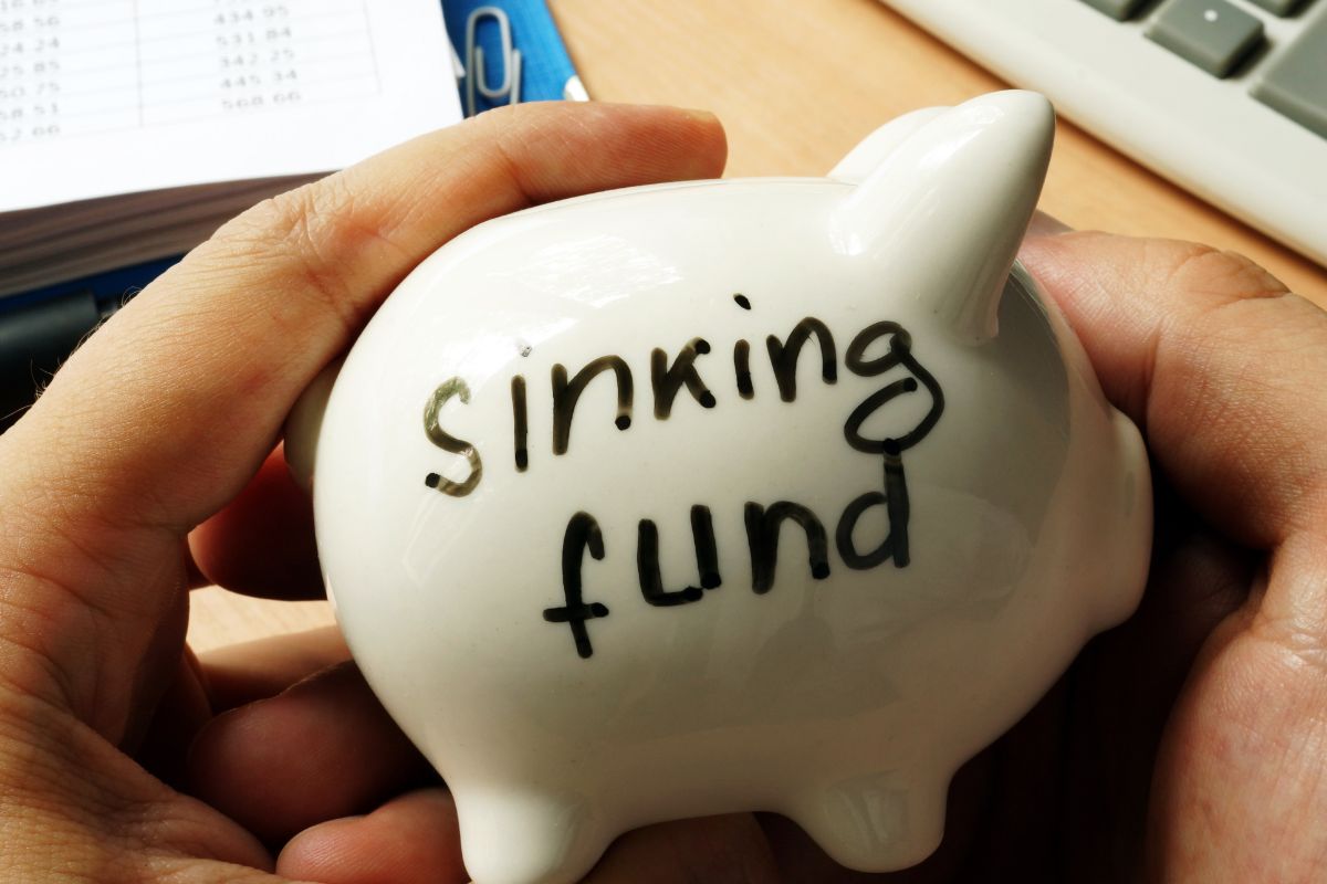 A man's hand holding a sinking fund.