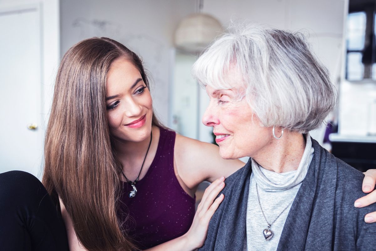 A young woman embracing her grandmother.
