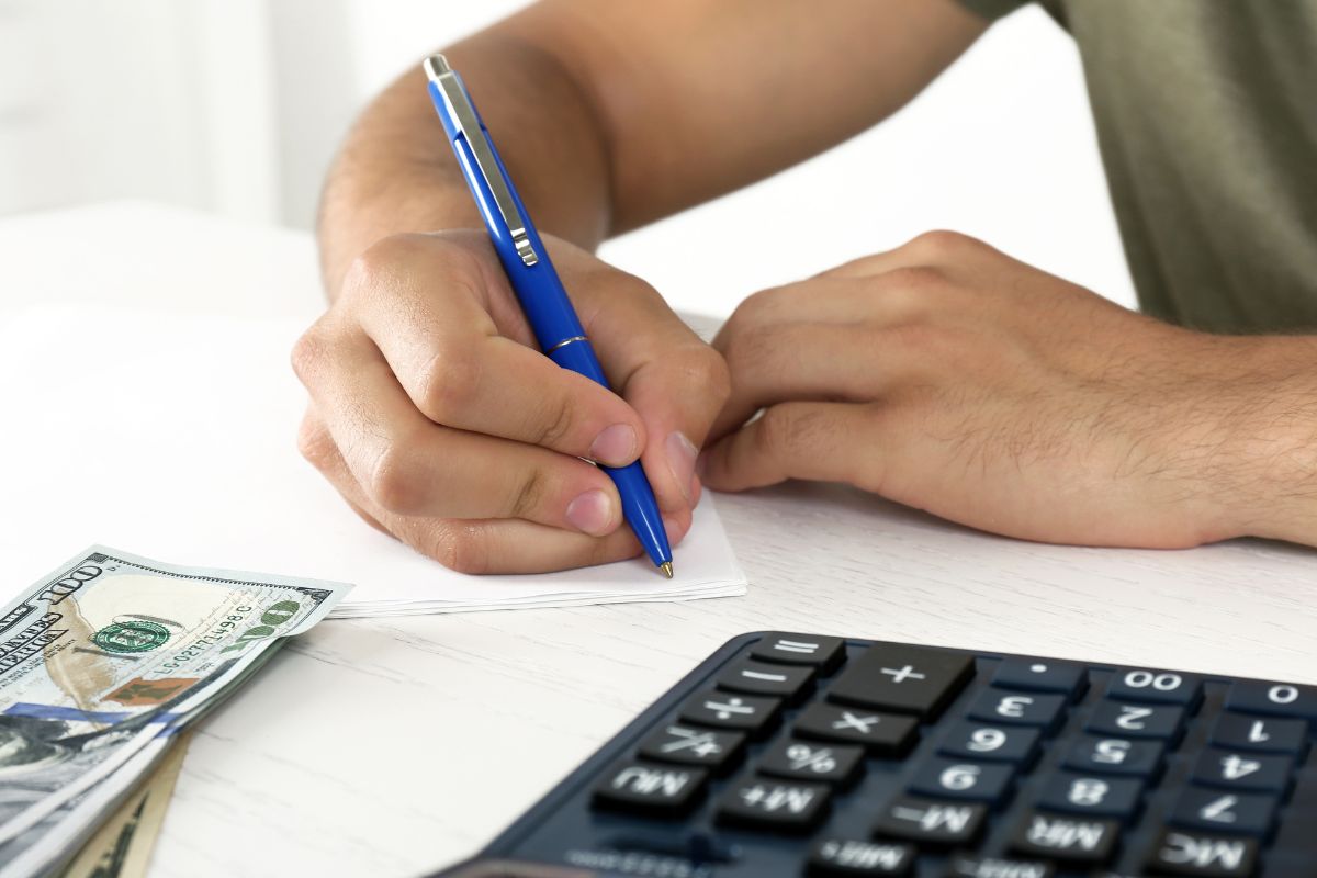 Picture of a man writing his expenses.