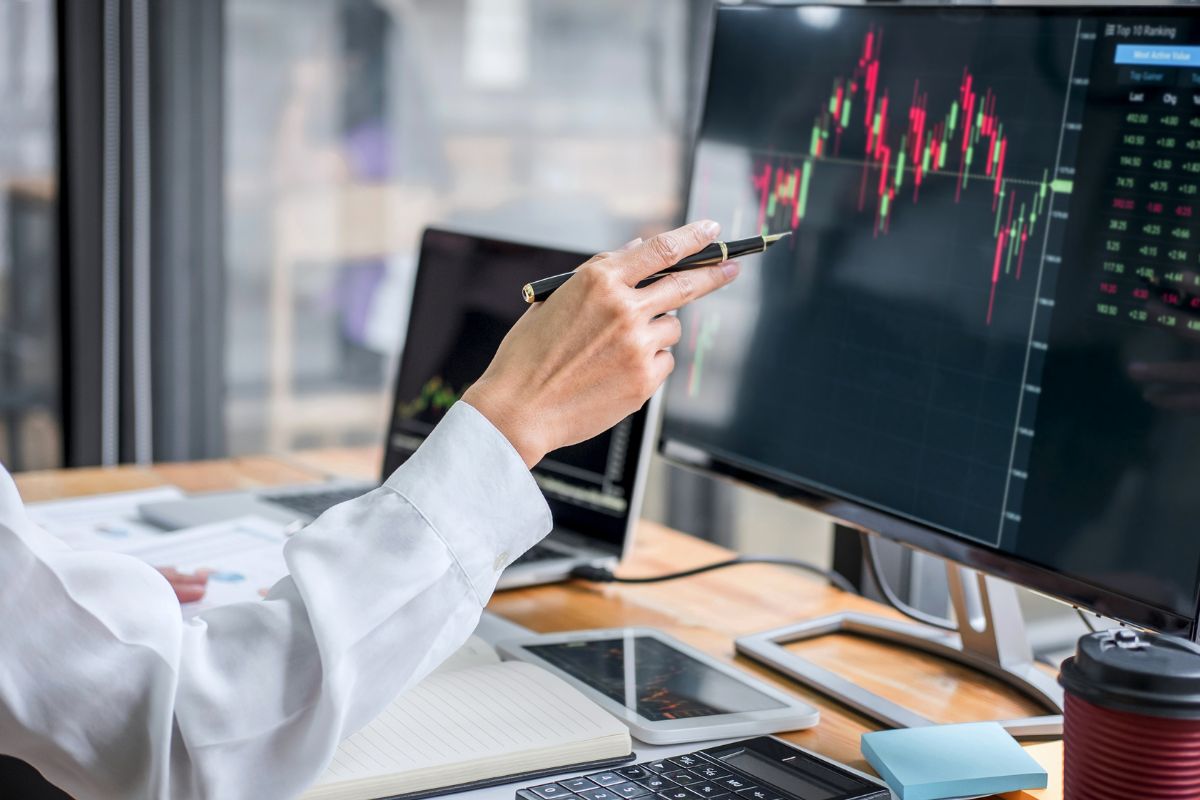 Photo of a man's hand analyzing the investment.