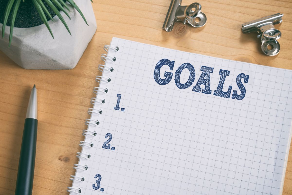 The image shows a notebook with goals wording.