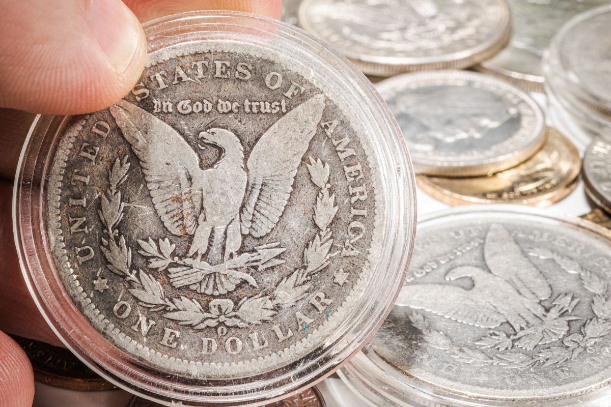 Picture of a man's hand collecting antique coins.