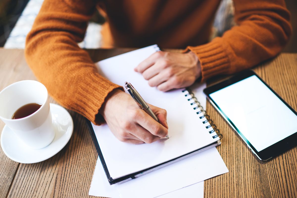 A woman is writing in a notebook.