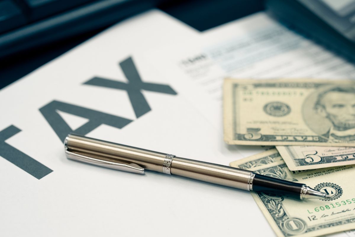 The picture shows money and tax papers.