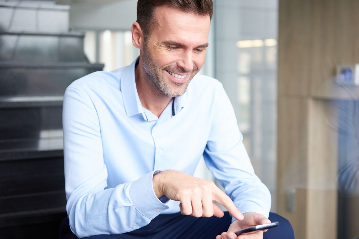 Photo of a man using a phone.