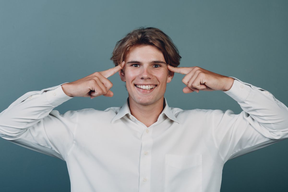 The picture shows a man pointing his head.