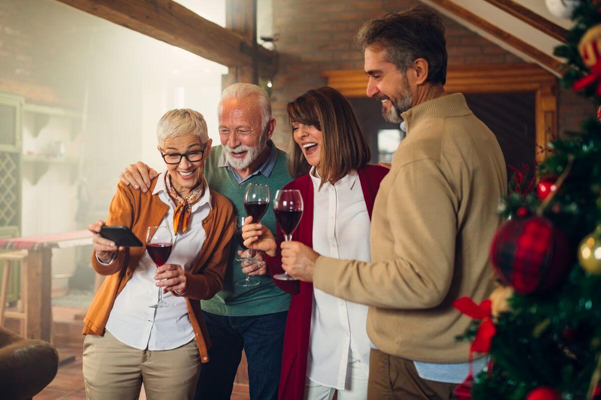 The picture shows a group of people having their wine while looking at their phones and smiling which refers to how giving experience over gifts can create lasting memories that stay with you forever.
