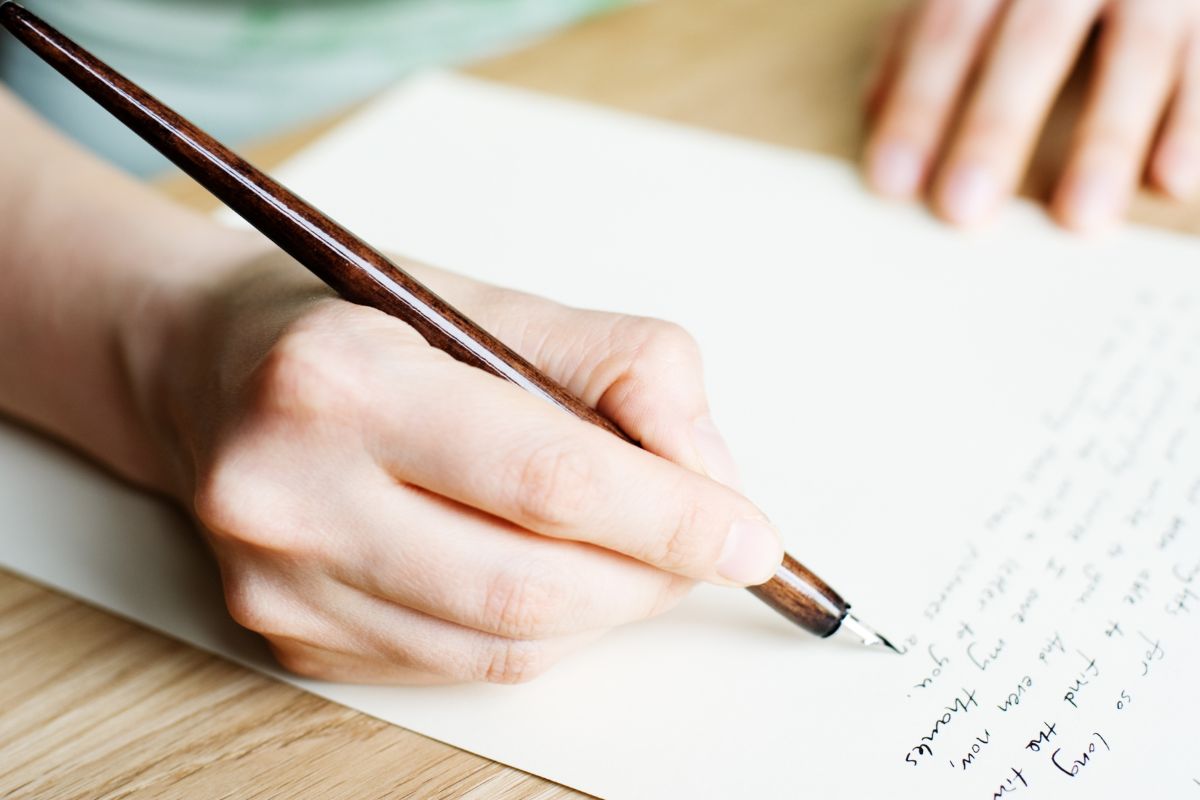 Picture of a woman's hand and writing on a paper.