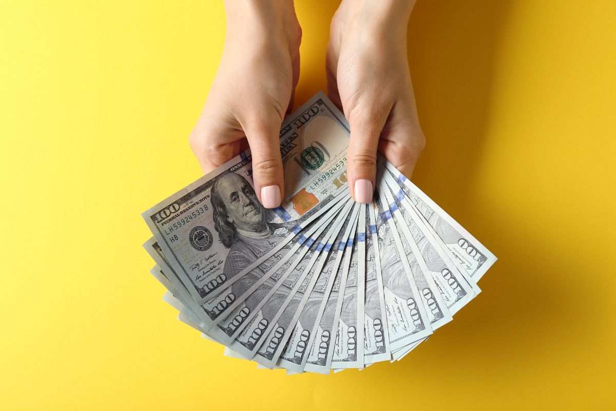 A woman's hand holding investment money.