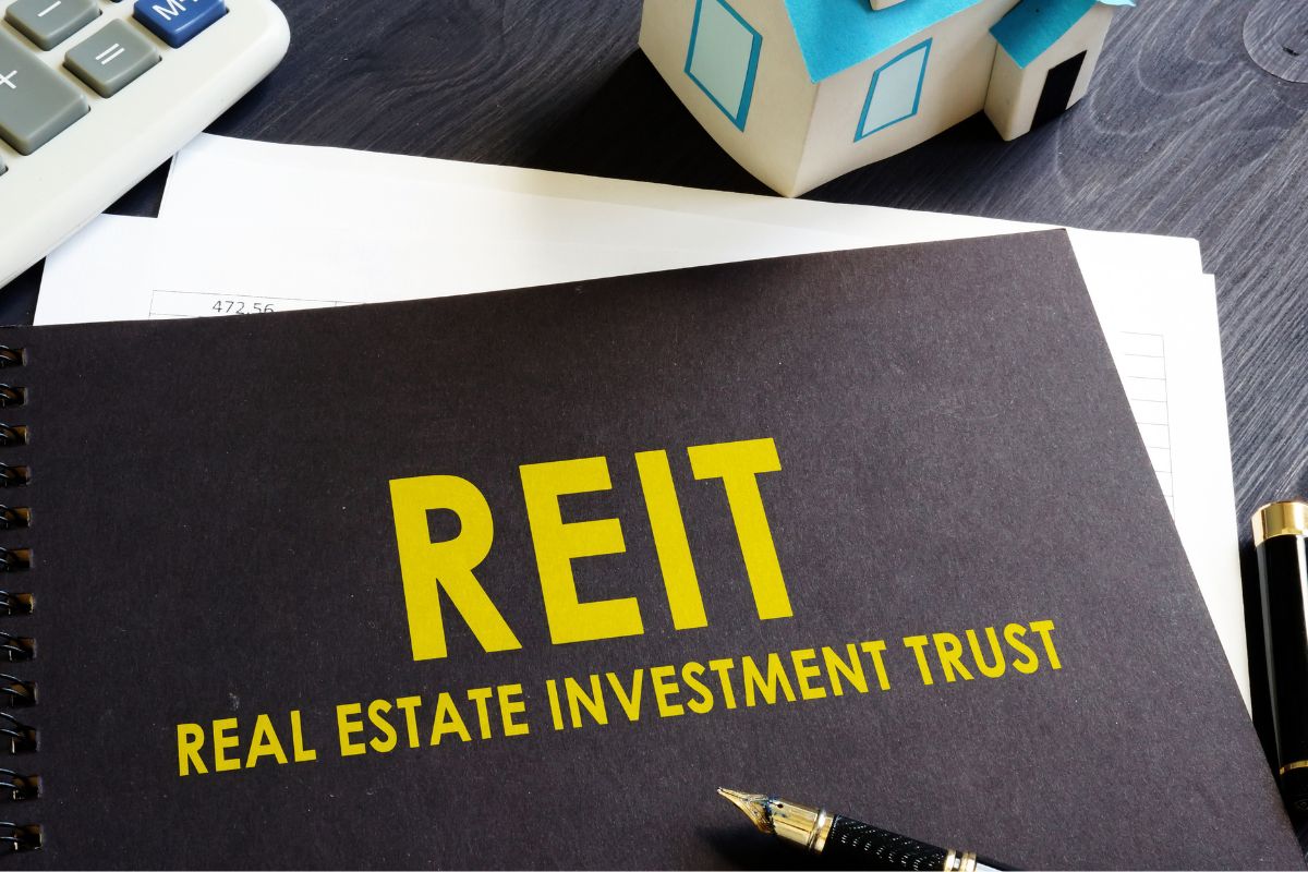 The image shows a REIT title on a notebook.