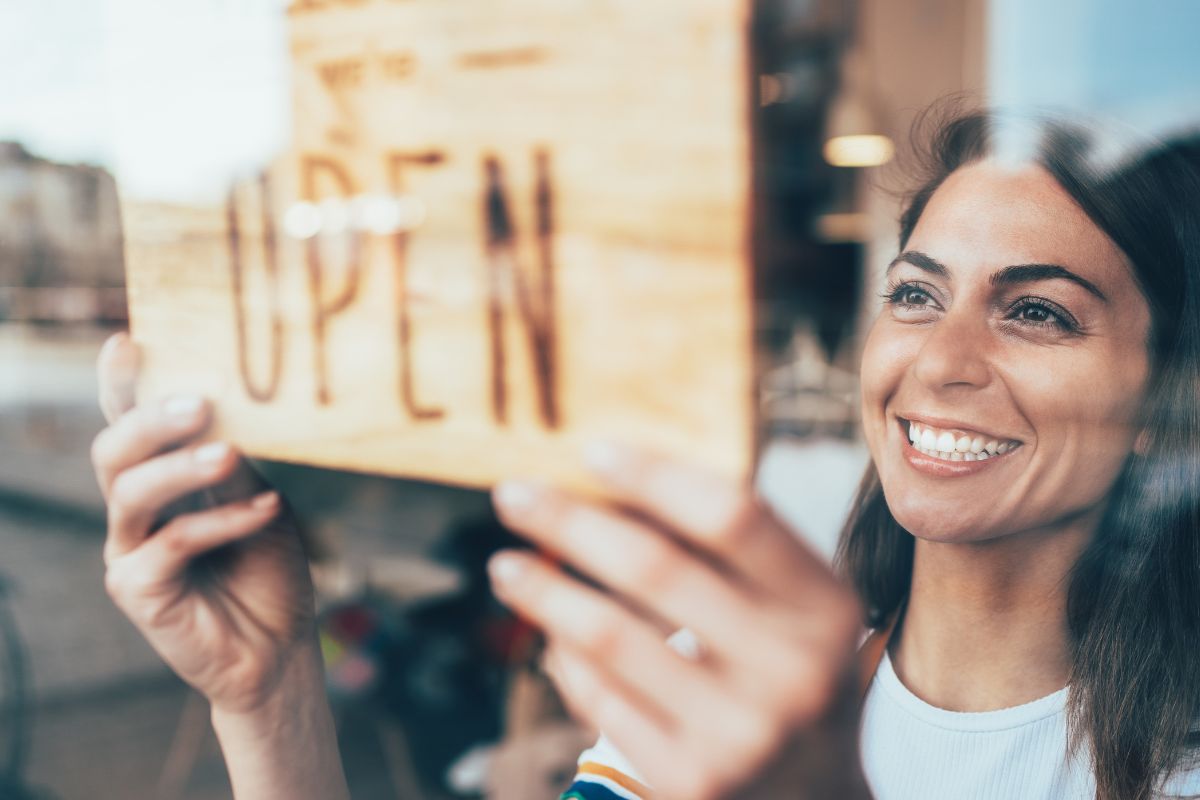 The photo shows a woman opening a business.