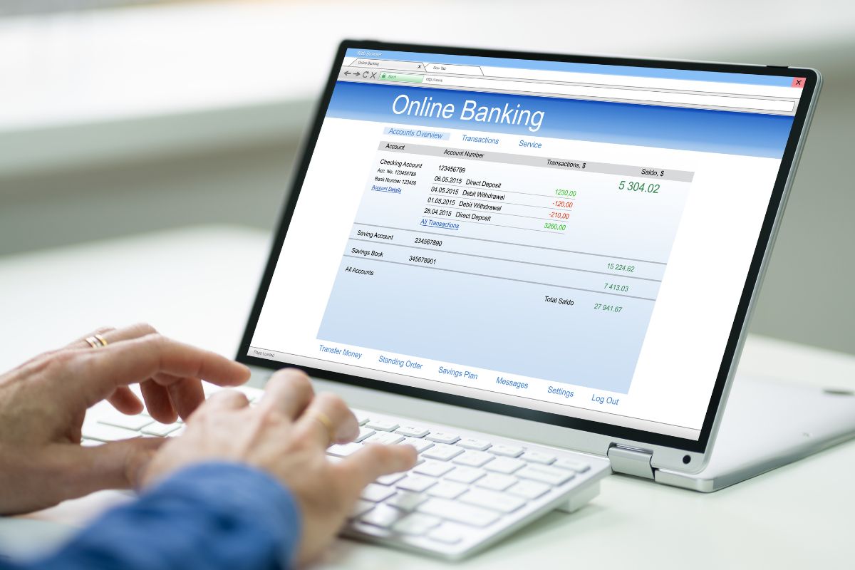 A man's hand checking his bank account online.