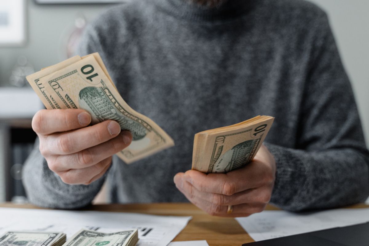 The image shows a man counting money.