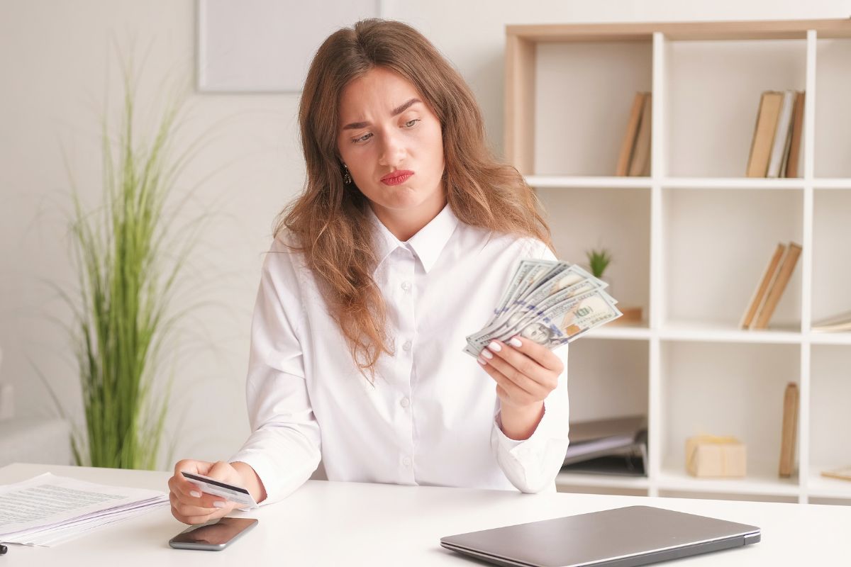 Picture of a woman holding money and a credit card.