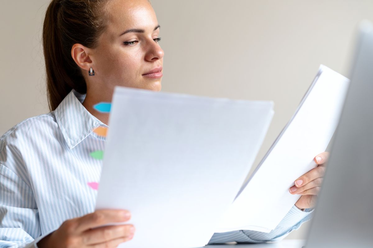 Photo of a woman reviewing the papers.