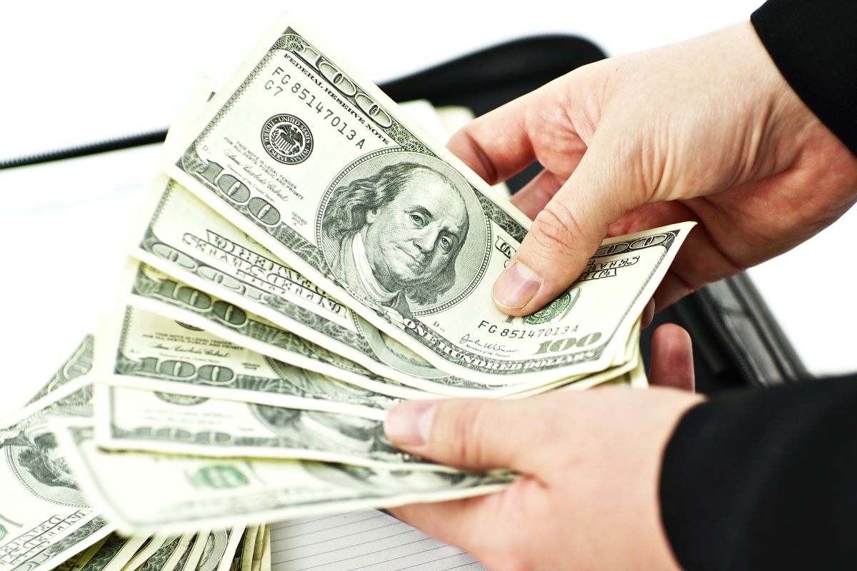 Picture of a man's hand counting money.