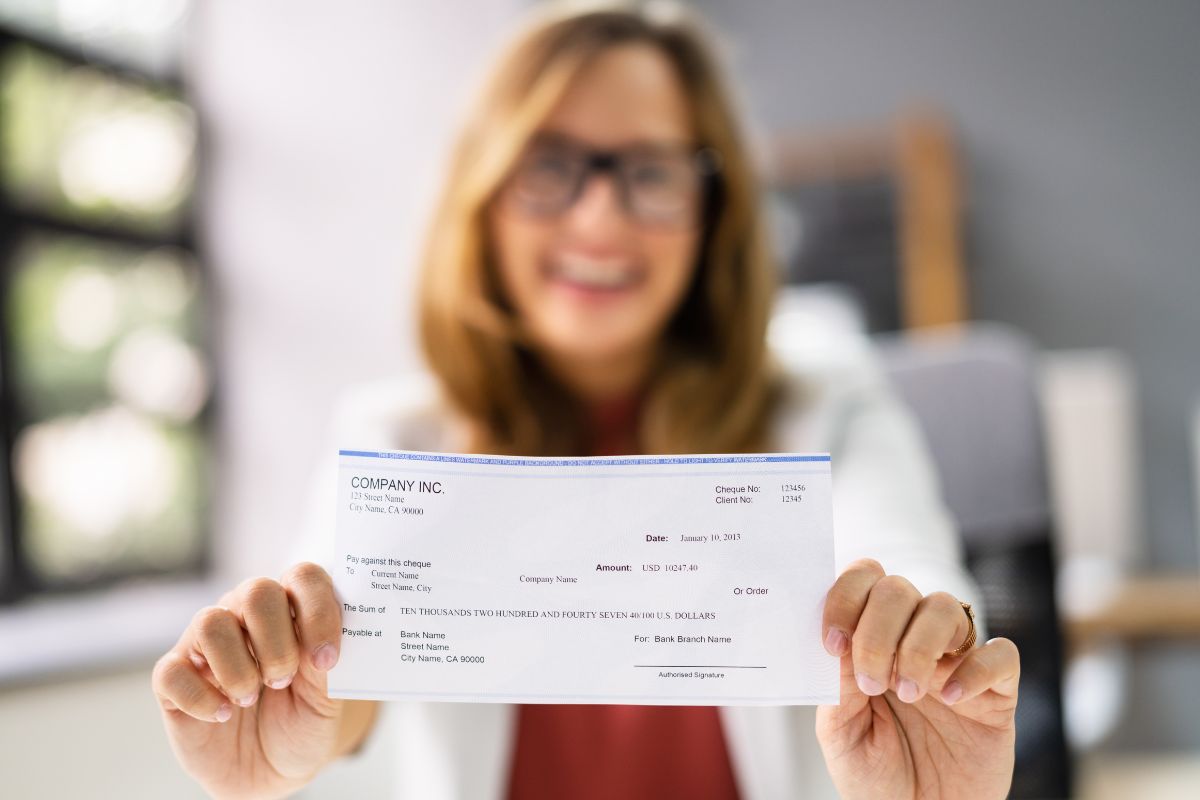 Photo d'une femme tenant un chèque.