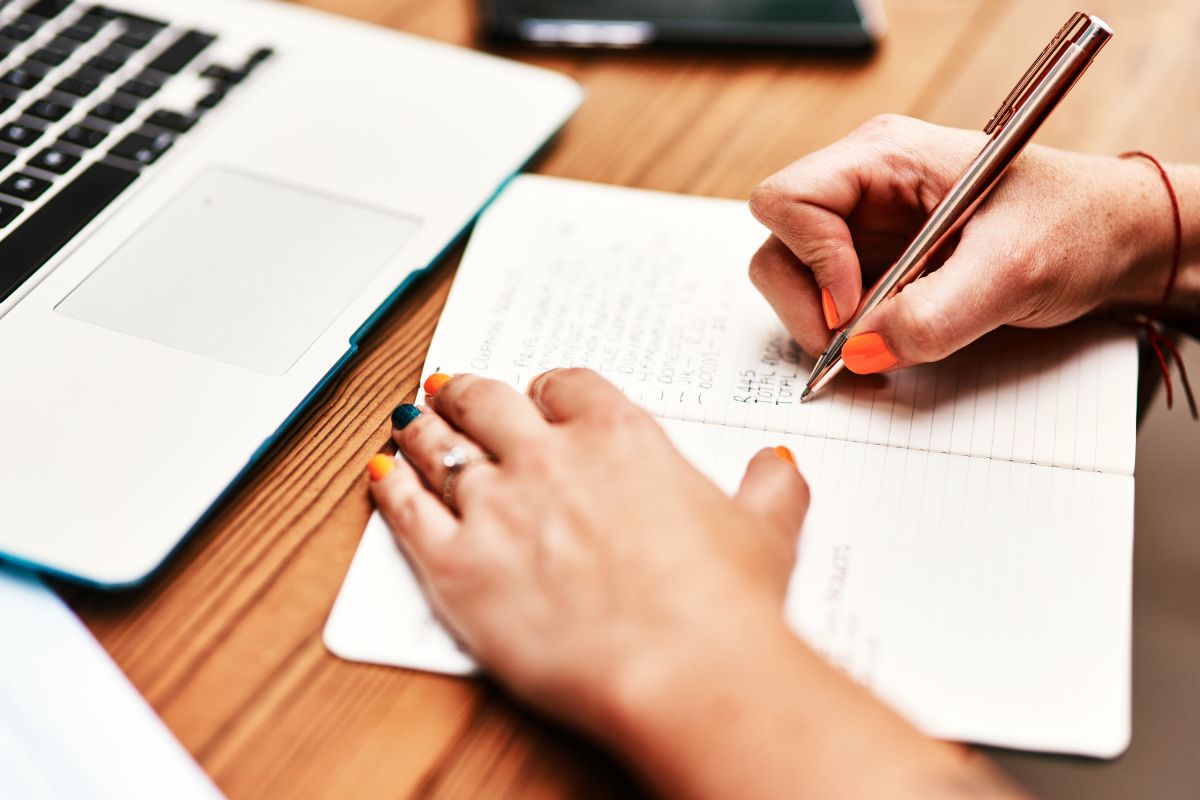 A woman's hand and writing in a notebook.